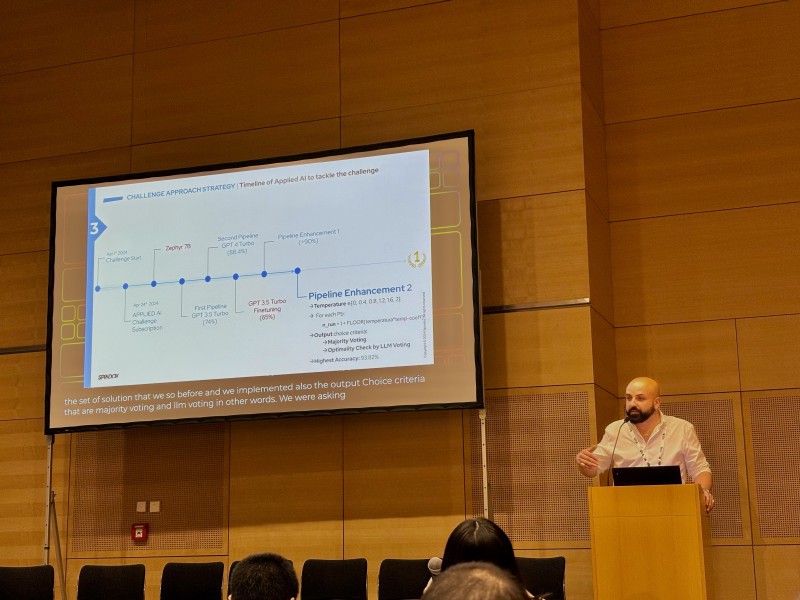 Raffaele Mariosa on stage presenting a slide titled “Challenge Approach Strategy”