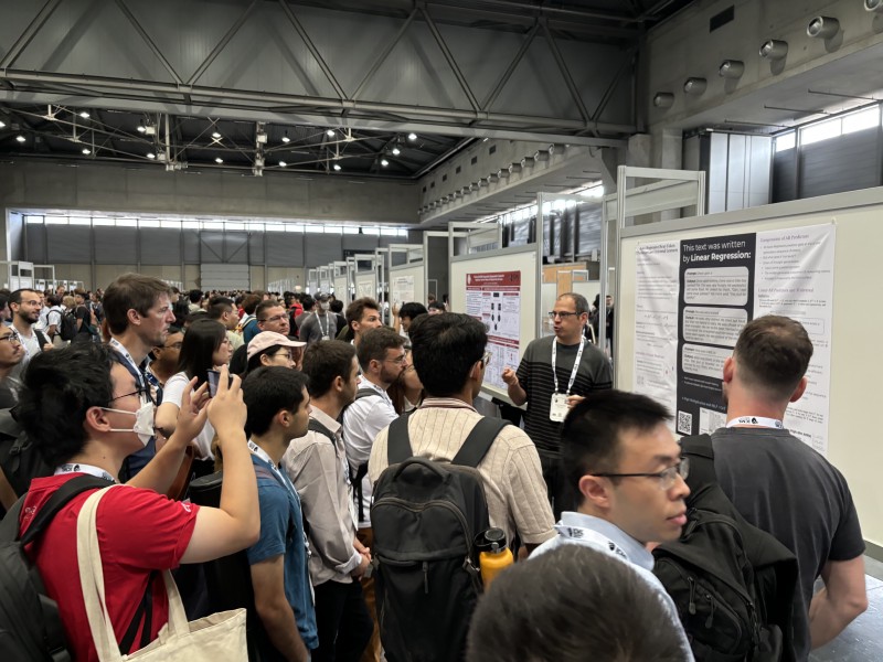 A crowd listens to a speaker at the ‘Auto-Regressive Next-Token Predictors are Universal Learners’ poster