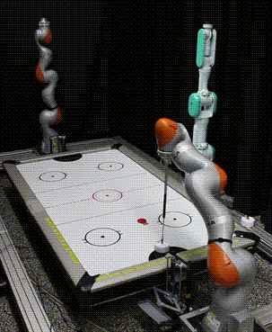 A robotic arm hitting an air hockey puck